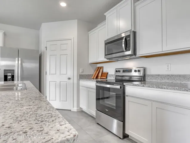a kitchen with stainless steel appliances granite countertop a refrigerator stove and sink