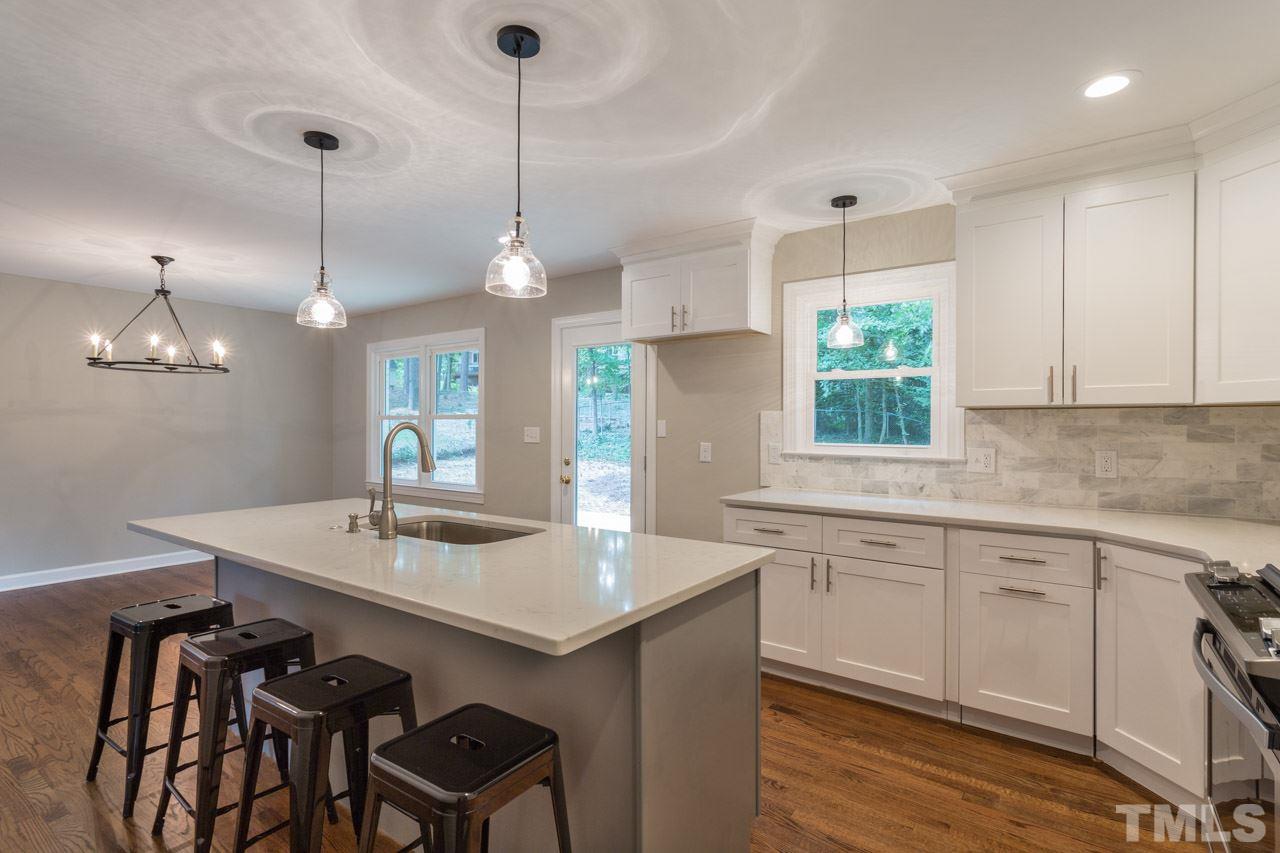 1509 Shadowood Lane Raleigh, NC 27612 - Photo 2 of 25 a kitchen with center island table and chairs in it