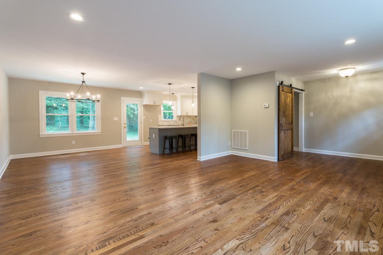 1509 Shadowood Lane Raleigh, NC 27612 - Photo 11 of 25 an empty room with wooden floor fireplace and windows