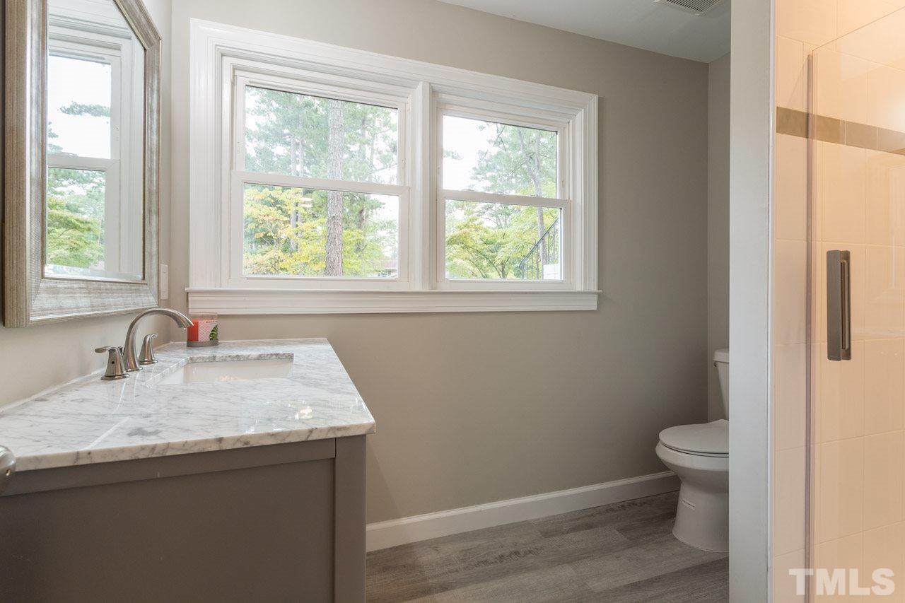 1509 Shadowood Lane Raleigh, NC 27612 - Photo 13 of 25 a bathroom with a granite countertop sink toilet and a window