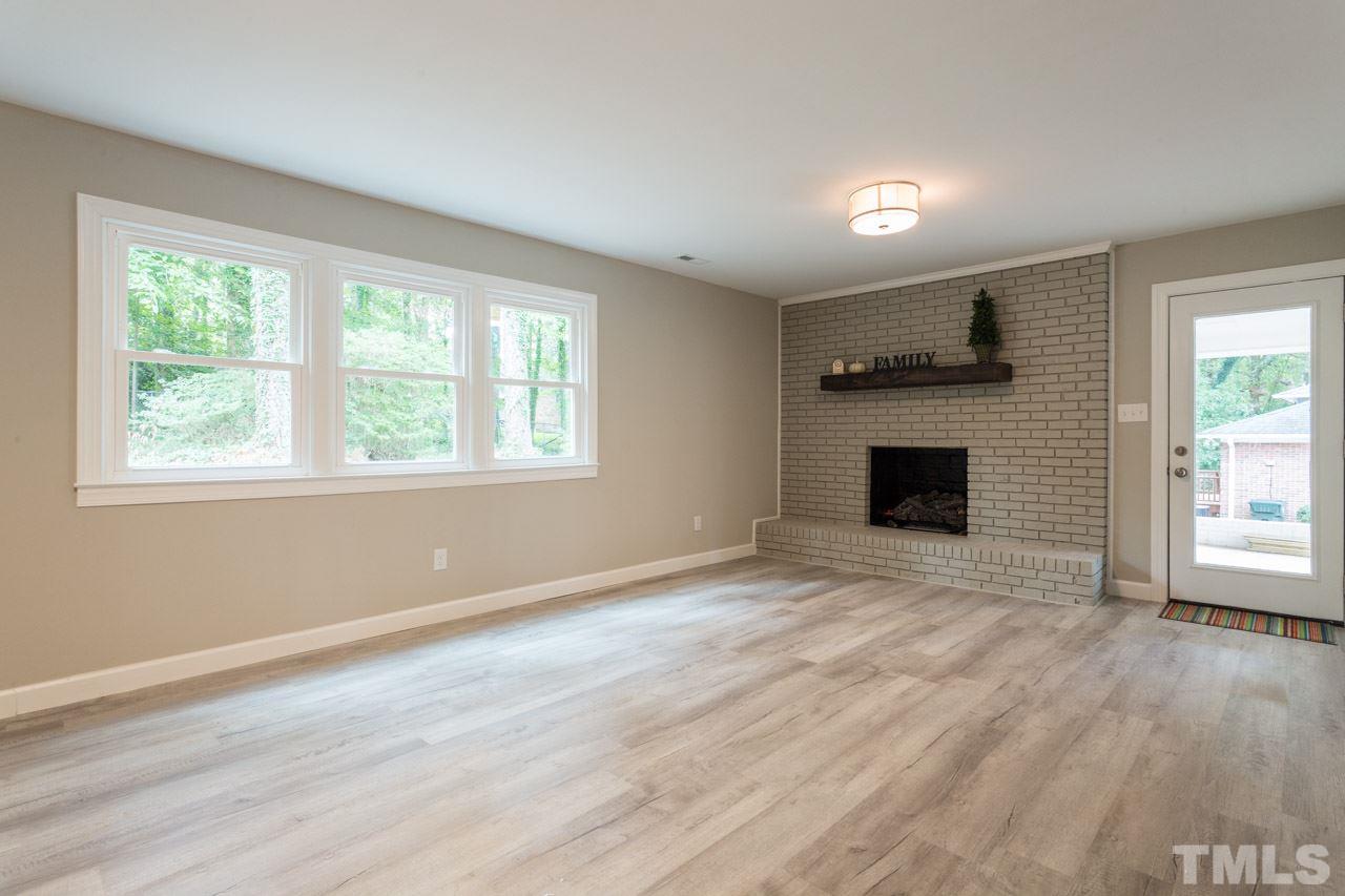 1509 Shadowood Lane Raleigh, NC 27612 - Photo 19 of 25 a view of empty room with wooden floor and fireplace