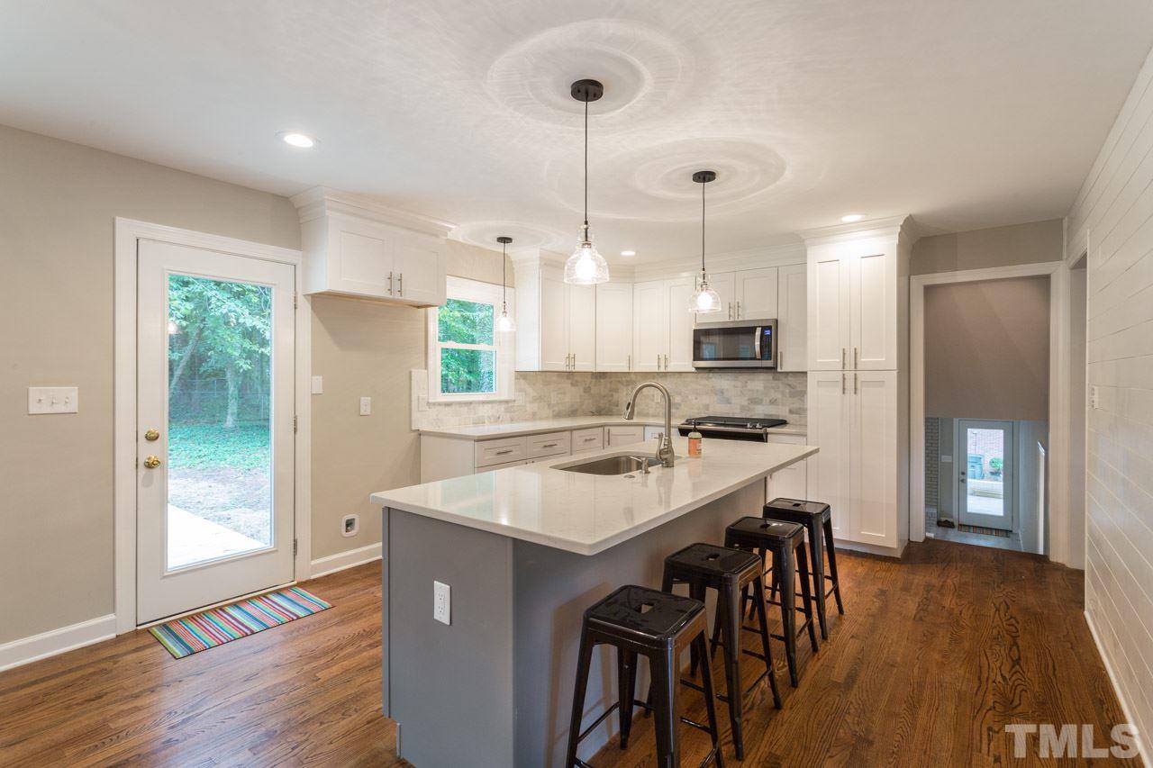 1509 Shadowood Lane Raleigh, NC 27612 - Photo 7 of 25 a kitchen with kitchen island a sink stove and refrigerator