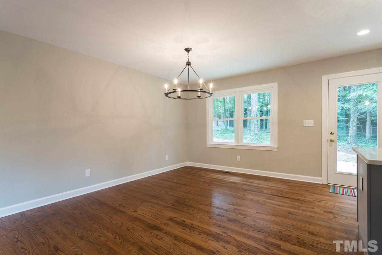 1509 Shadowood Lane Raleigh, NC 27612 - Photo 10 of 25 a view of empty room with wooden floor chandelier and window