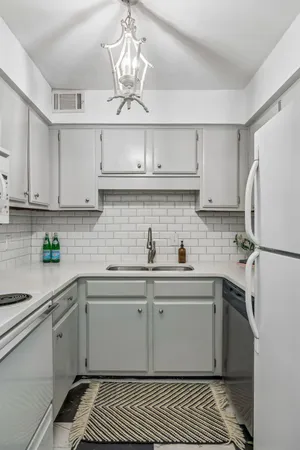 a kitchen with white cabinets and white appliances
