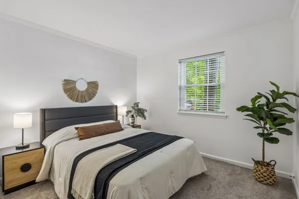 a bedroom with a bed and a potted plant