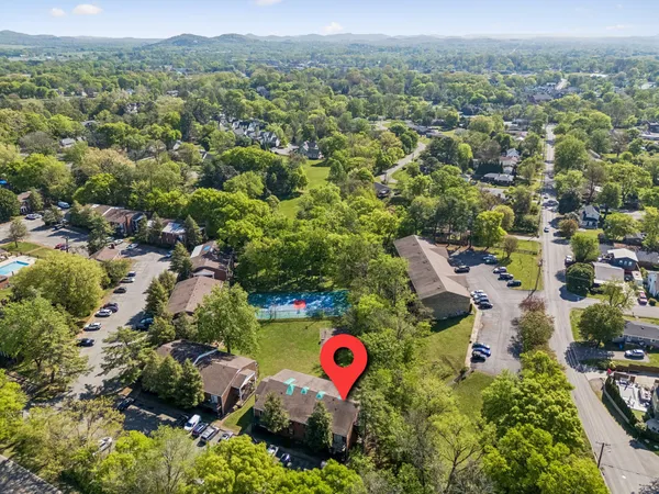 an aerial view of residential houses with outdoor space and trees