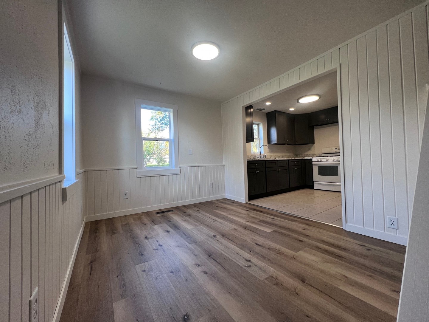 14707 Caledonia Road Caledonia, IL 61011 - Photo 36 of 37 a view of a kitchen and an empty room with wooden floor and a window