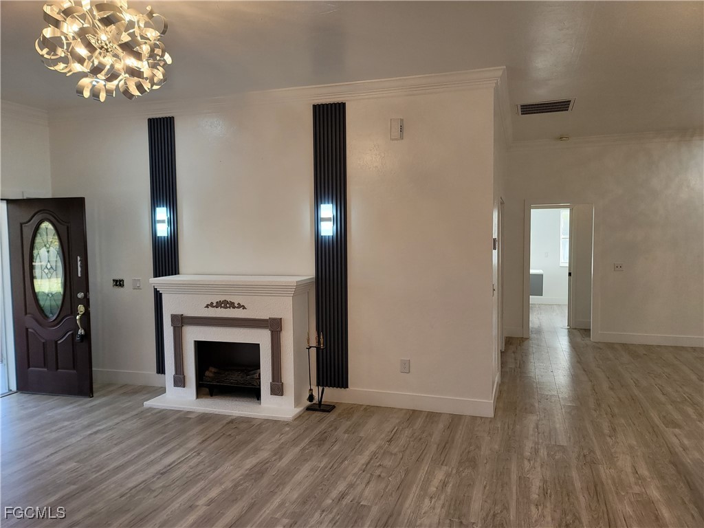 7820 Rich Road North Fort Myers, FL 33917 - Photo 20 of 26 an empty room with wooden floor fireplace and a window