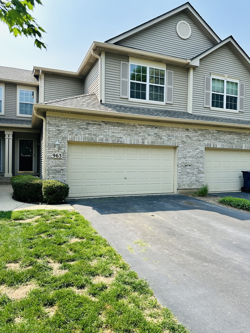 a front view of a house with a yard and garage