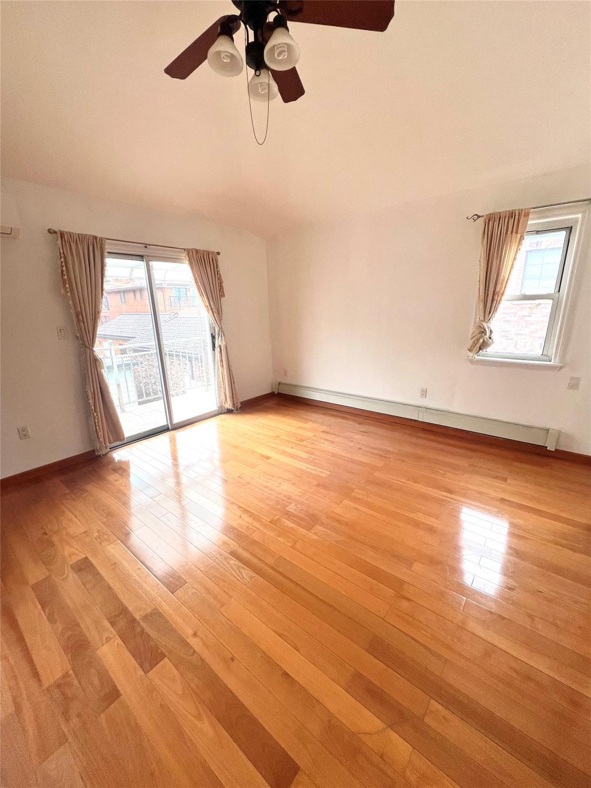 200-29 45th Road, Unit 2 Queens, NY 11361 - Photo 6 of 14 wooden floor in an empty room with a window