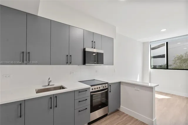 a kitchen with a sink and a stove top oven