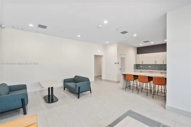 a kitchen with stainless steel appliances kitchen island granite countertop a table and chairs in it
