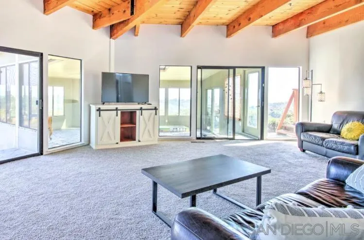404 Hidden Valley Road Watsonville, CA 95076 - Photo 21 of 69 a living room with furniture a flat screen tv and floor to ceiling window