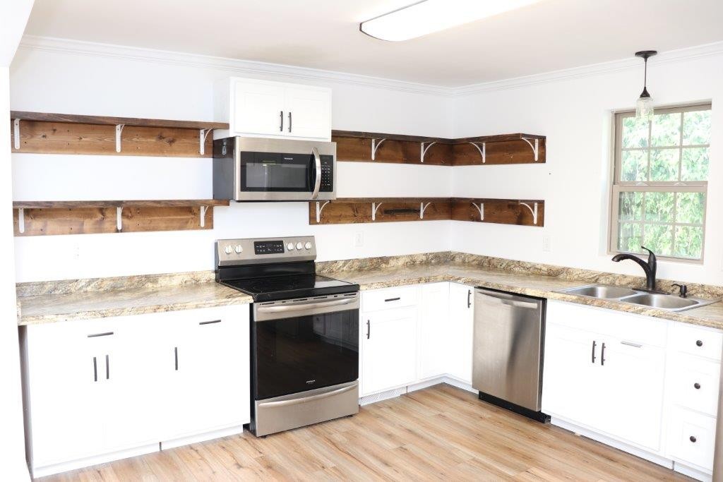 6431 Old Bottom Road Pleasant Shade, TN 37145 - Photo 9 of 38 a kitchen with stainless steel appliances granite countertop a stove a sink and a microwave