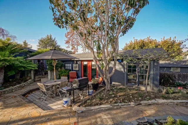 a patio with wooden floor a yard a table and chairs
