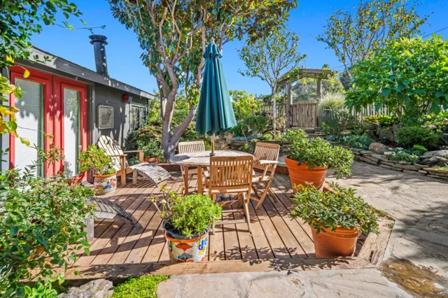 a view of a chairs and table in patio with a barbeque