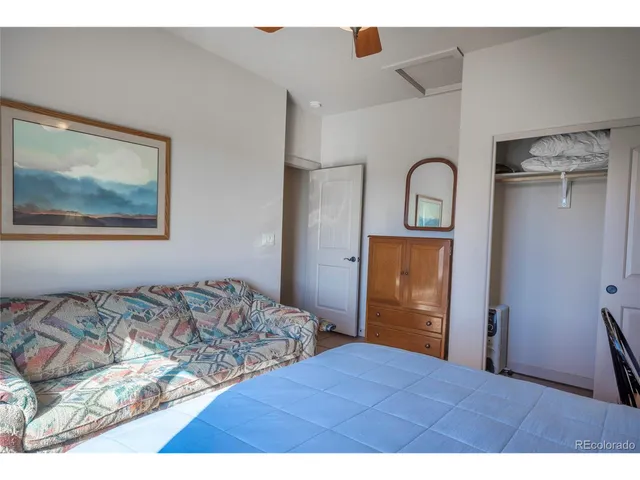 a bedroom with a bed and a painting on the wall