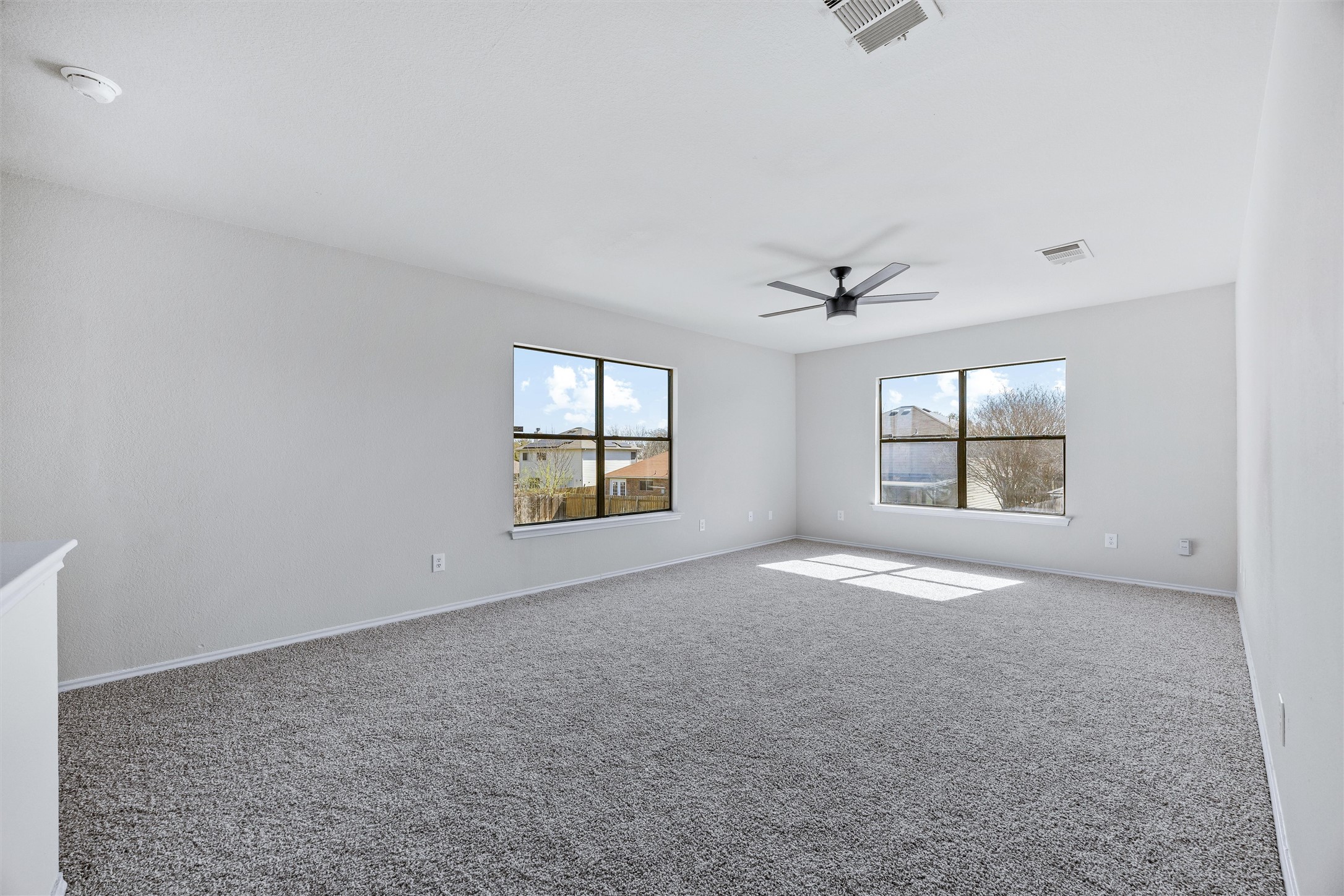 7541 Redrick Drive Austin, TX 78747 - Photo 26 of 40 Spare room featuring a wealth of natural light, visible vents, and carpet flooring