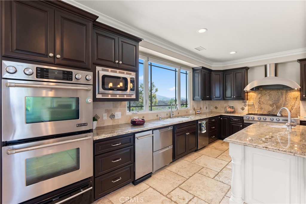 3 Windy Ridge Road Trabuco Canyon, CA 92679 - Photo 28 of 59 a kitchen with stainless steel appliances granite countertop wooden cabinets a stove top oven a sink and dishwasher