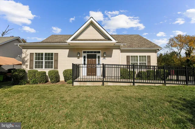 a view of a house with a yard and fence