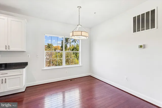 a kitchen with stainless steel appliances granite countertop a refrigerator a stove and a wooden floors