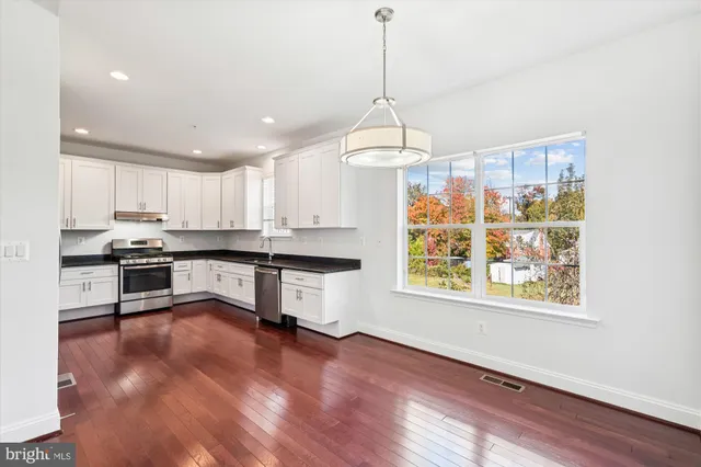 a kitchen with granite countertop wooden floors and white appliances