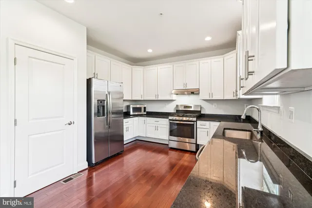 wooden floor in an empty room with a kitchen
