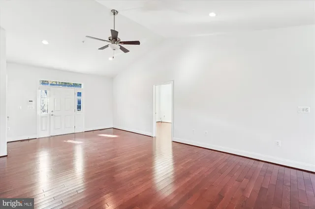 a view of an empty room with a window and wooden floor