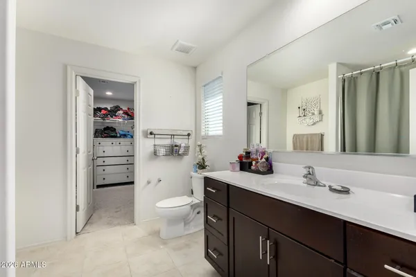 a bedroom with a bed couches and a flat tv screen
