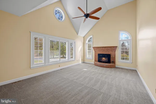 a view of an empty room with a fireplace and a window