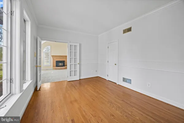 a view of empty room with wooden floor and entryway