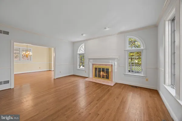 an empty room with windows and fireplace
