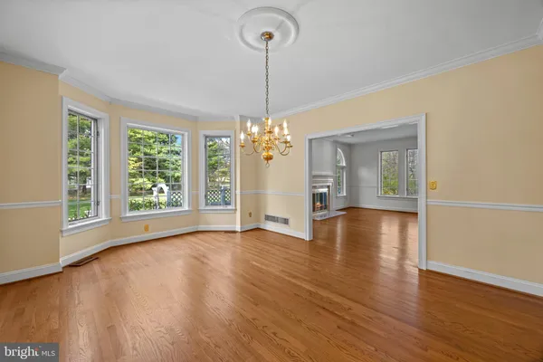 a view of a room with wooden floor chandelier and windows