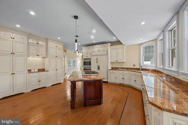 a large kitchen with kitchen island a large counter space a sink appliances and cabinets