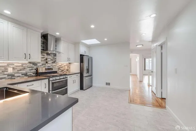 a kitchen with stainless steel appliances granite countertop a refrigerator and a stove
