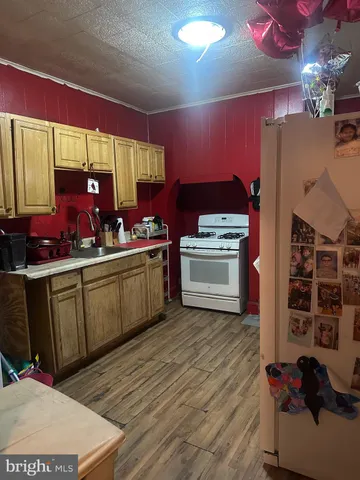 a kitchen with stainless steel appliances kitchen island granite countertop a sink dishwasher and a stove with wooden floor