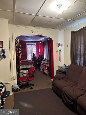 a living room with furniture a flat screen tv and gym equipment