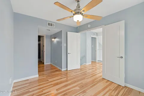 a view of a livingroom with wooden floor and a ceiling fan