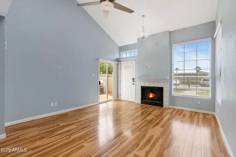 a view of a livingroom with wooden floor a fireplace and windows