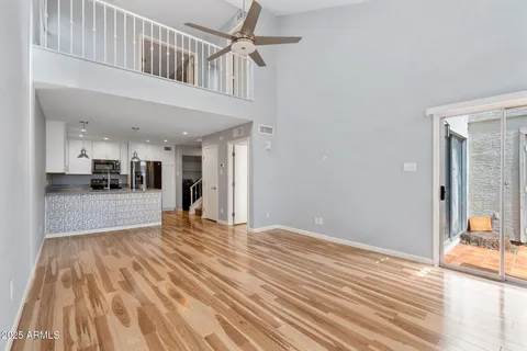 a view of a living room and a kitchen with wooden floor