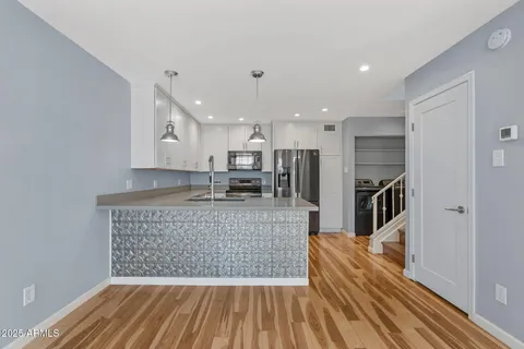 a kitchen with kitchen island a counter top space a sink stainless steel appliances and cabinets