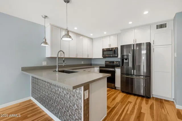 a kitchen with kitchen island a sink appliances a counter space and wooden floor