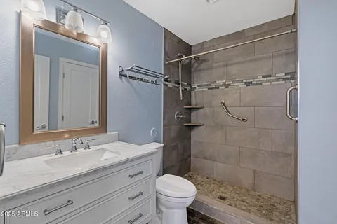 a bathroom with a granite countertop sink toilet and shower
