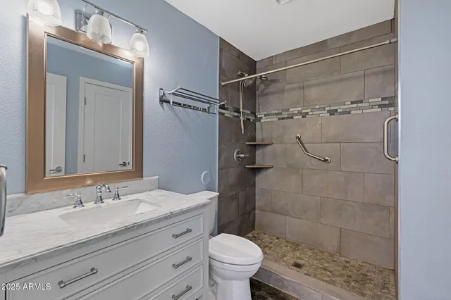 a bathroom with a granite countertop sink toilet and shower