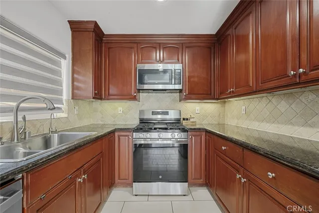 a kitchen with granite countertop a sink stove and cabinets