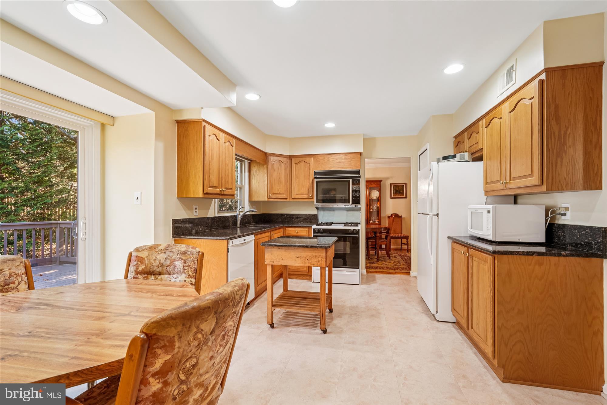 15417 Aylesbury Street Silver Spring, MD 20905 - Photo 12 of 65 a kitchen with stainless steel appliances kitchen island granite countertop a refrigerator a stove top oven a sink dishwasher and white cabinets with wooden floor