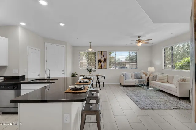 a kitchen with a sink dishwasher a stove and white cabinets