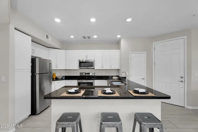 a kitchen with stainless steel appliances a refrigerator a stove a microwave and cabinets