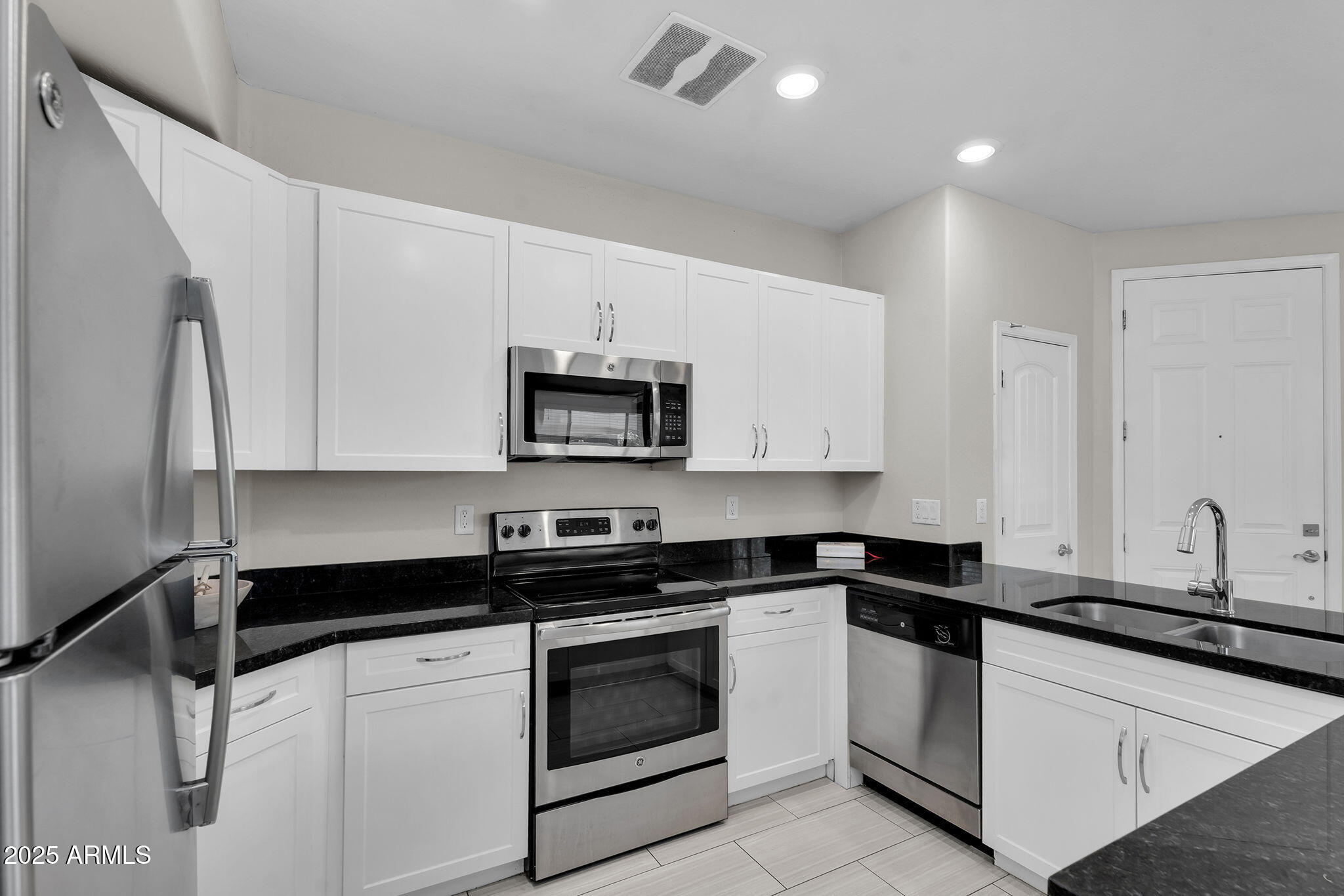 3330 South Gilbert Road, Unit 1075 Chandler, AZ 85286 - Photo 12 of 70 a white kitchen with granite countertop a sink a stove and cabinets
