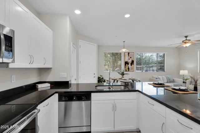a kitchen with stainless steel appliances kitchen island granite countertop a dining table and chairs